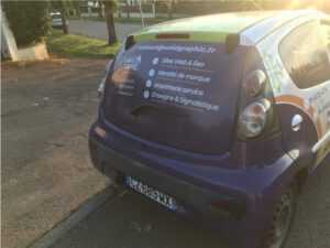 Total Covering Automobile, Vue Arrière Montrant L'Adhésif Micro-Perforé Sur La Lunette Arrière Et Le Vinyle Sur Le Pare-Chocs Arrière